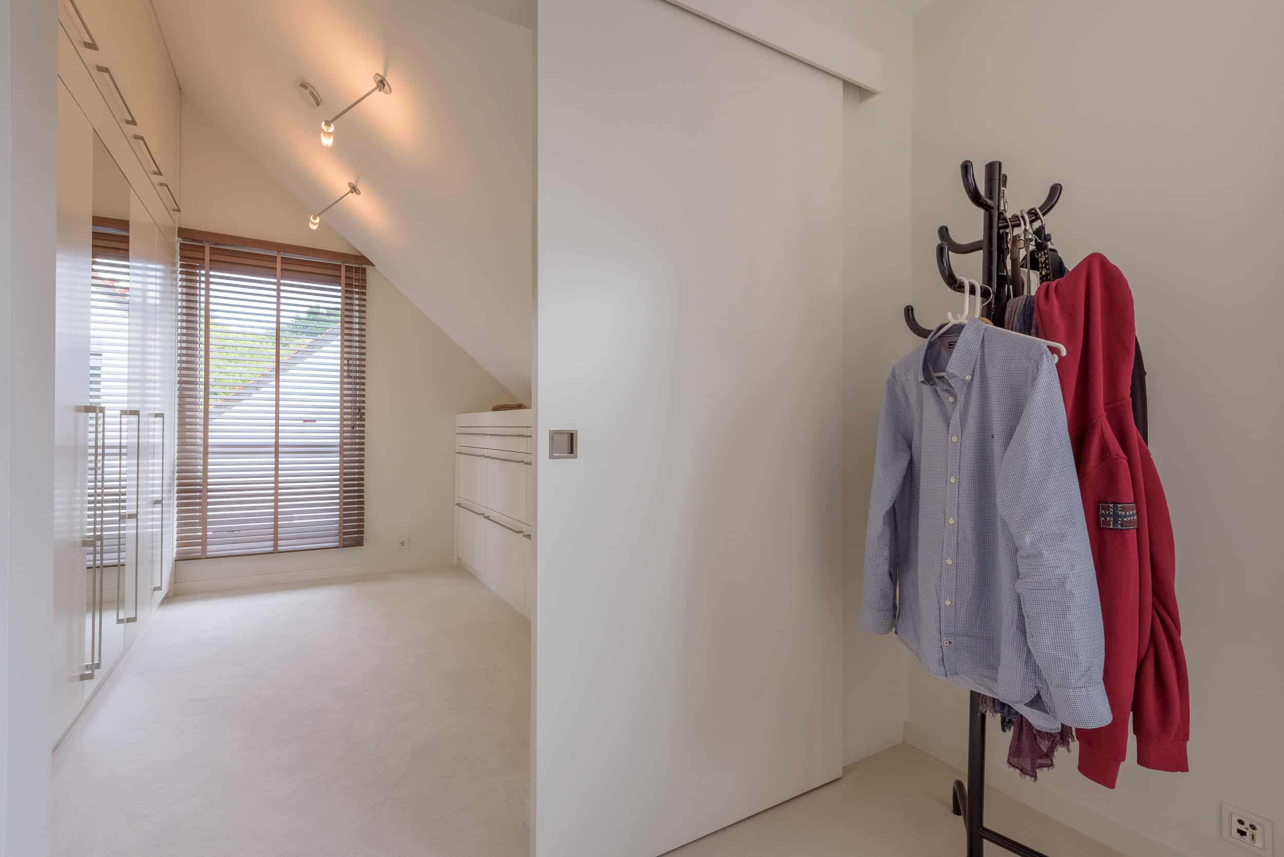 Ein komplettes Zimmer für die Ankleide mit stilvollen Einbauschränken und großen Spiegeln